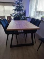 Stół Loft Trapez z drewnianym blatem i czarną metalową podstawą w nowoczesnej jadalni. Zdjęcie aranżacyjne pokazujące stół z krzesłami oraz jego proporcje we wnętrzu.